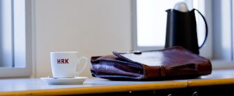 Symbolfoto: Nahaufnahme einer HRK-Kaffeetasse, einer Aktentasche und einer Thermoskanne