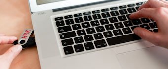Symbolfoto: Ein USB-Stick mit HRK-Schriftzug in einem Laptop.