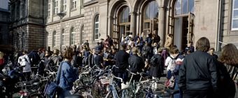 Symbolfoto: Eingangsportal einer Hochschule. Studierende strömen hinein.