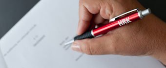 Symbolfoto: Nahaufnahme einer Hand mit HRK-Kugelschreiber
